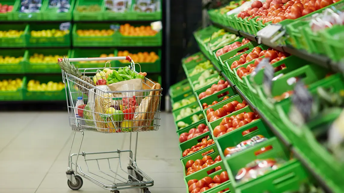 Carro de compras com mercearias num supermercado