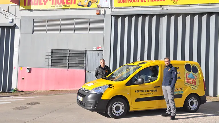 Disinfestation technicians next to a Truly Nolen car